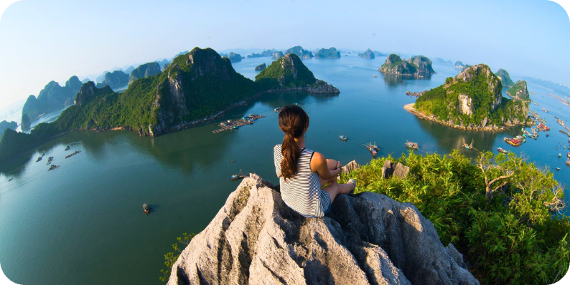 A Volunteer in Vietnam sitting on a rock watching the horizon and water.